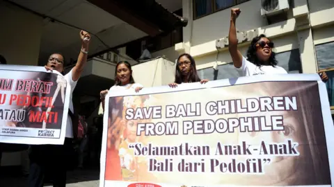 AFP Activists display banners against paedophilia in front of a holding cell where Australian Robert Andrew Fiddes Ellis was waiting before attending his trial at a court in Denpasar, on the Indonesian resort island of Bali on July 14, 2016.