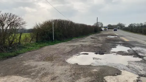 Laura Coffey/BBC A pile of grit on a verge next to a road. 