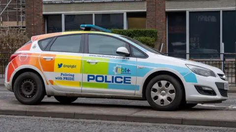A Northumbria Police car parked in the city centre. It has been decorated in Pride colours and has the words Policing with Pride displayed on its door.