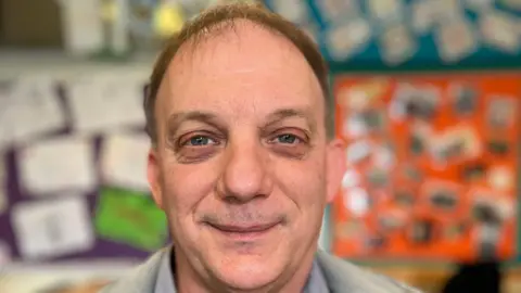 Parent Charles Smith in a grey jacket in a classroom