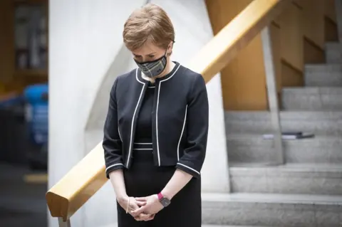 PA Media Nicola Sturgeon bows her head during a minute's silence