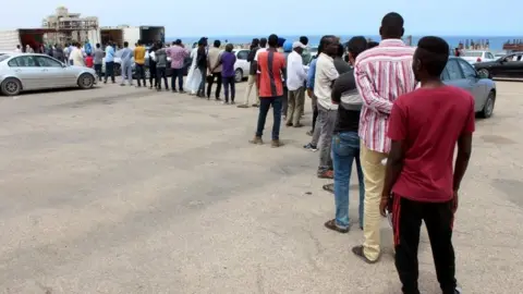 Reuters Migrants queue for food aid. Libya is a major transit point for attempts to reach Europe. File image