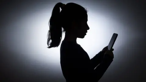 Getty Images Unidentified girl looking at mobile phone