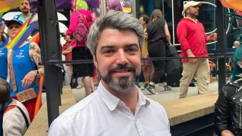 Matt Shannon with people walking by behind him