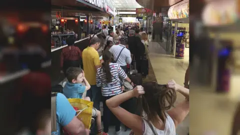 Lee Nazari Passengers queue in Tenerife airport