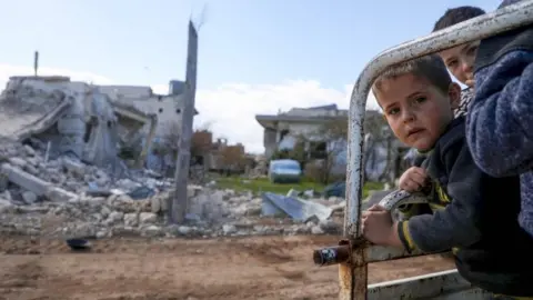 AFP Displaced children stand on the back of a lorry in Nayrab, Idlib province, Syria (29 March 2020)