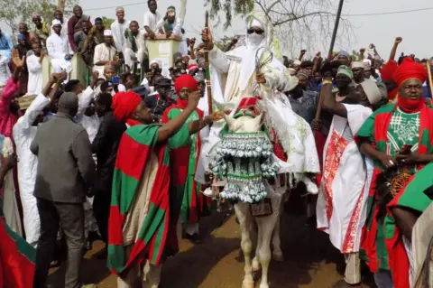 AFP The Emir of Kano Muhammadu Sanusi II departs on horseback from the Eid prayer ground in Kano, Nigeria - 25 June 2017