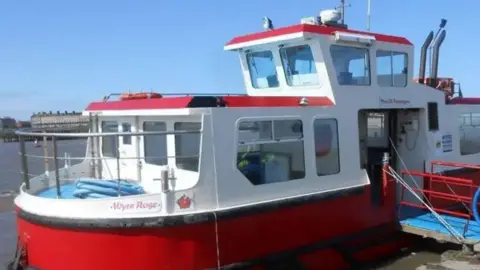 The small red and white ferry at the harbour with its drawbridge out