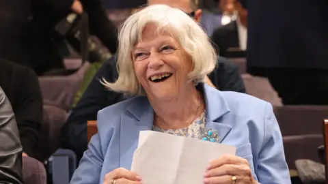 Ann Widdecombe in a blue blazer, laughing.