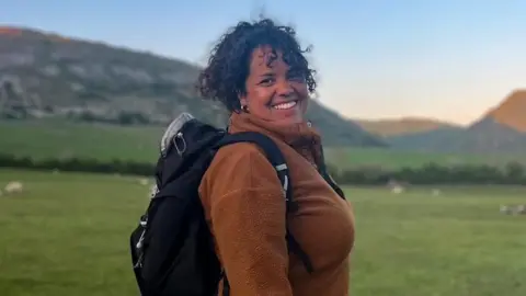 Leanne Wharton from Soul Trial Wellbeing smiling into the camera, stood in a field.