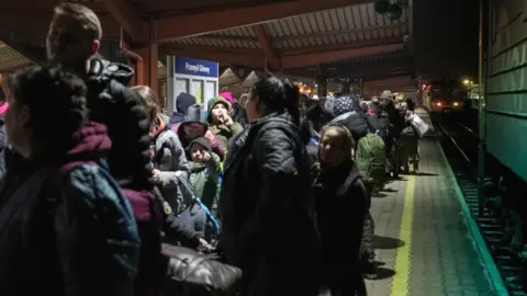 Bruno Boelpaep/BBC People on the platform at Przemysl train station in Poland