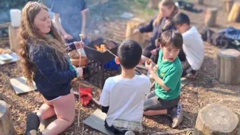 Pupils toasting marshmallows in forest school