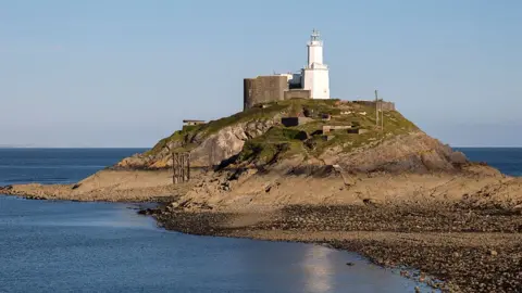 Getty Images Lighthouse at low tide Mumbles Head, Gower peninsula, near Swansea, South Wales, UK.