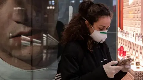 Getty Images Woman checking her phone in Milan