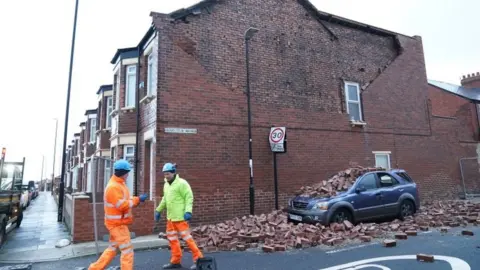 PA Media Workmen block off an area of fallen masonry from a property, which has damaged a nearby car, on Gloucester Avenue in Roker, Sunderland