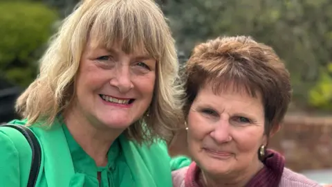 Ali France, a deaf social care worker, standing outside with her arm around Sarah Forsyth, a woman she helped. 