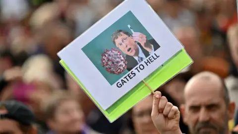 AFP A protester holds up an anti-Bill Gates placard in Trafalgar Square in London on September 26, 2020, at a 'We Do Not Consent!' mass rally against vaccination