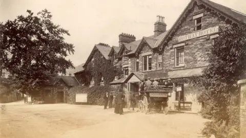 Black and white image of tourists arriving on a charabanc named Wordsworth at the Rothay Hotel in Grasmere in 1890.