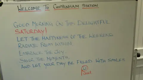 A whiteboard message board that says Welcome to Chippenham Station, along with a positive quote for Saturday