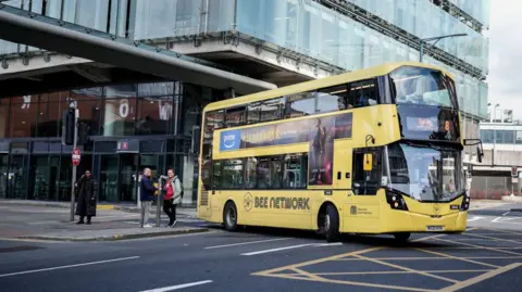 Getty Images Bus tingkat kuning bermerek 'Bee Network' di pusat kota Manchester