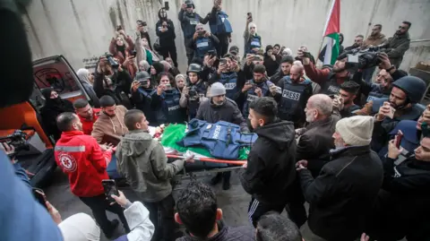 Getty Images Palestinian mourners and journalists carry the body of journalism student Shatha al-Sabbagh outside Jenin government hospital.