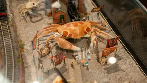 Sam Bush A model of a giant orange crab with red spots towering above miniature figures of people at Crab Museum in Margate 