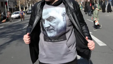 EPA An Iranian boy wears a T-shirt bearing an image of Qasem Soleimani with a slogan reading "we are all Soleimani" during a funeral ceremony in Tehran, 6 January 2020