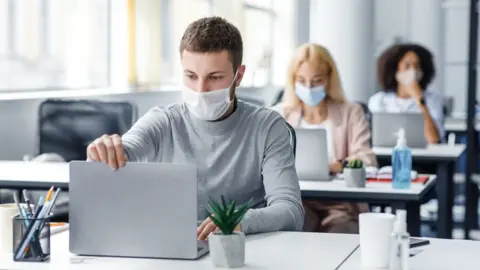 Getty Images Staff wearing masks in office