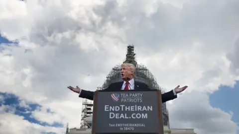 The Washington Post via Getty  Trump speaks outside Capitol in front of a sign saying 'EndTheIranDeal.com'