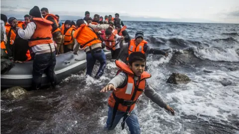 Getty Images Image shows refugees arriving on the shores of the Greek island of Lesbos in October 2015