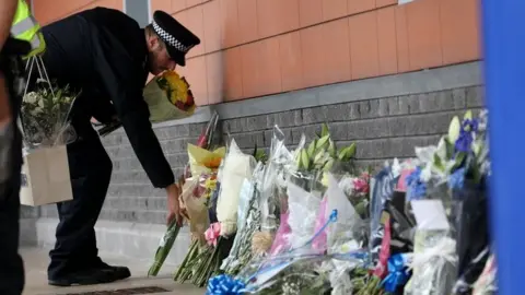 Reuters Police officer laying flowers