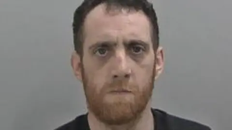 Joe-Lewis Tyler in his mugshot photo against a clear background. 