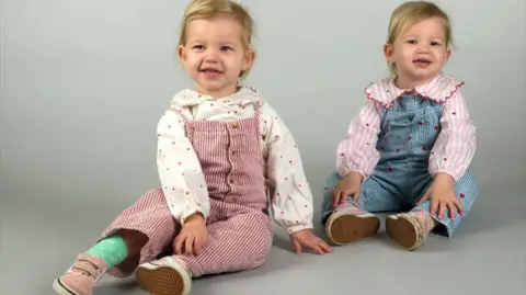 Leicester Royal Infirmary Fleur and twin siste, Ottilie, sitting down in a studio shot