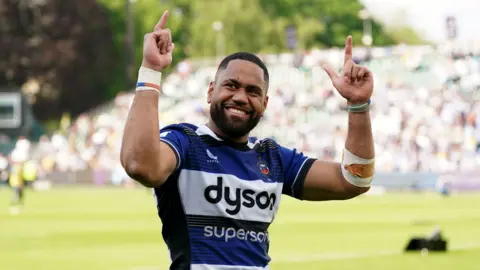 Joe Cokanasiga holds his hands up and points to the sky in celebration