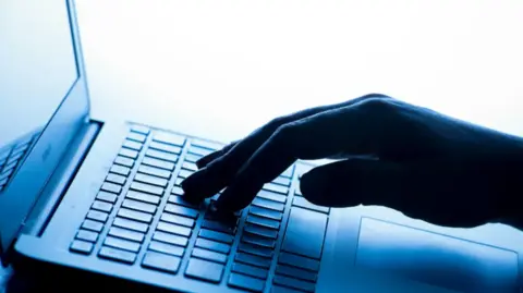 A close up of a hand typing on a laptop keyboard.