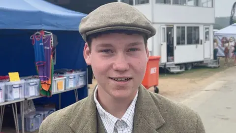 A young farmer wearing a cap speaks to the camera at the Great Yorkshire Show
