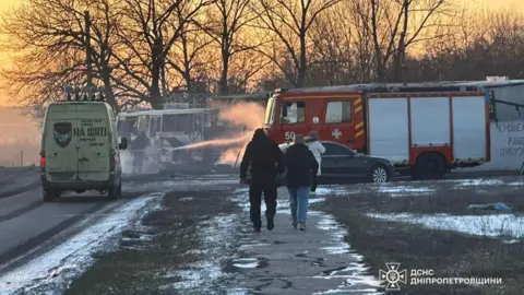 State Emergency Service of Ukraine A bus at twilight beside a fire engine