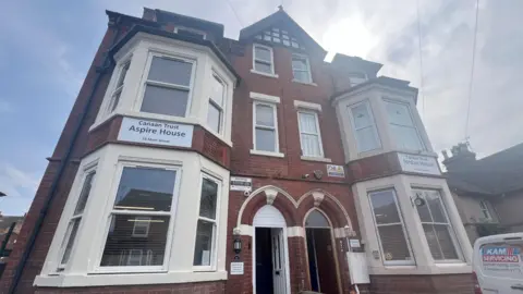 Large orange brick Victorian terrace house with windows with cream painted frames