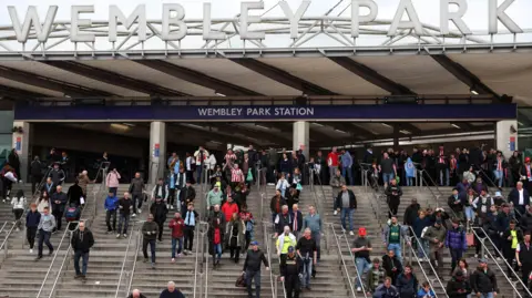 Getty Images Dozens of football fans make their way down steps at Wembley Park Station.