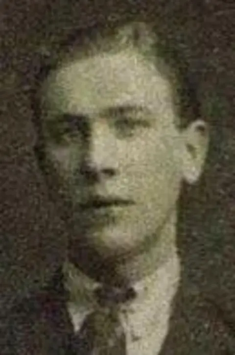 Ministry of Defence A black and white image showing a man with short, swept back hair.  He is wearing a collar and tie.