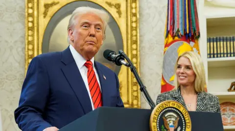 Donald Trump wears a blue suit, red tie with Pam Bondi standing next to him