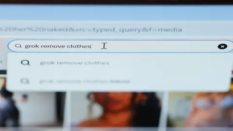 Getty Images A photo of a computer screen where there is a search engine. Someone has written into the search bar: Grok remove clothes.
