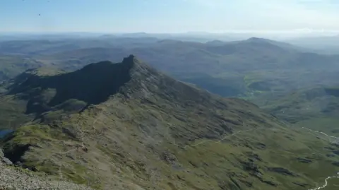 An aerial view of Yr Wyddfa with the Watkin Path seen across the landscape. 