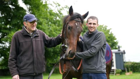 Trainer with horse and groom
