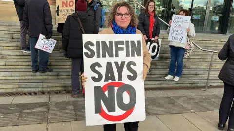 Nadine Peatfield holds up a sign reading "Sinfin says no"