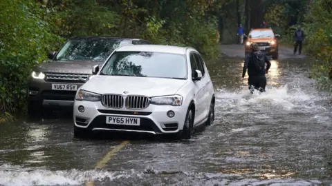 PA Media A broken down car in floodwater near Derwentwater