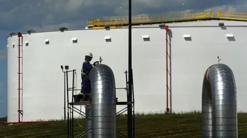 Getty Images A construction worker works on one of the pumping station outlets at the under construction Hardisty pipeline depot