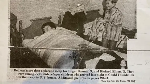 Brian Farmer/BBC Newspaper cutting showing photograph of boy lying in bed, and a second boy in pygamas standing nearby, plus caption. The cutting says the photograph was taken by John De Biase