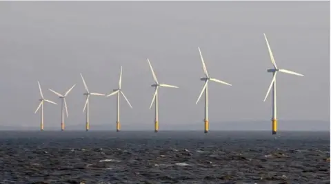 Seven wind turbines stick out of the sea