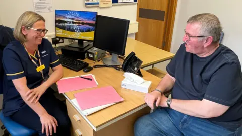 A nurse chats to her male patient.